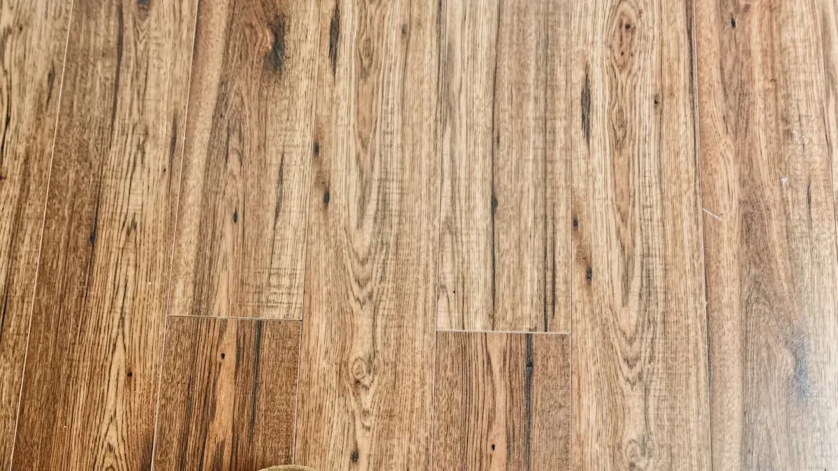Installer fitting new oak hardwood planks in the living room of an older Massachusetts home