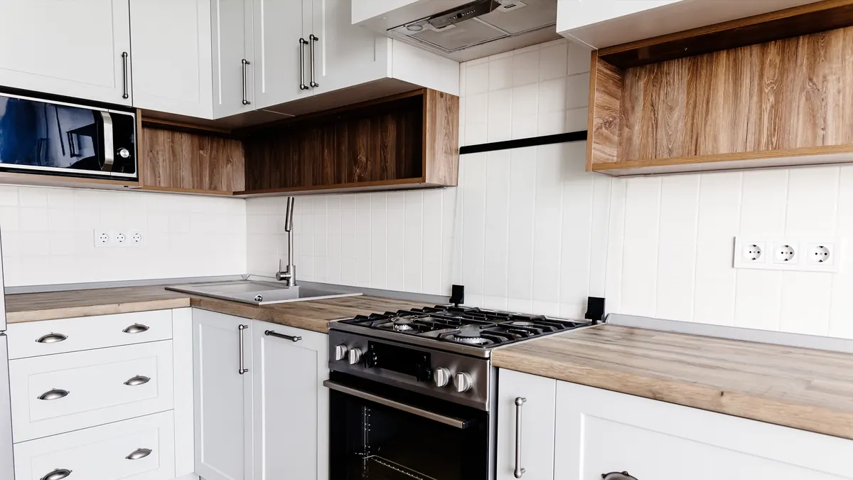 New white shaker kitchen cabinets being leveled and installed in a Greater Boston kitchen remodel
