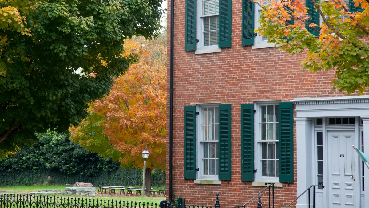 Brick rowhouses and wood triple-deckers side by side on a Boston residential street