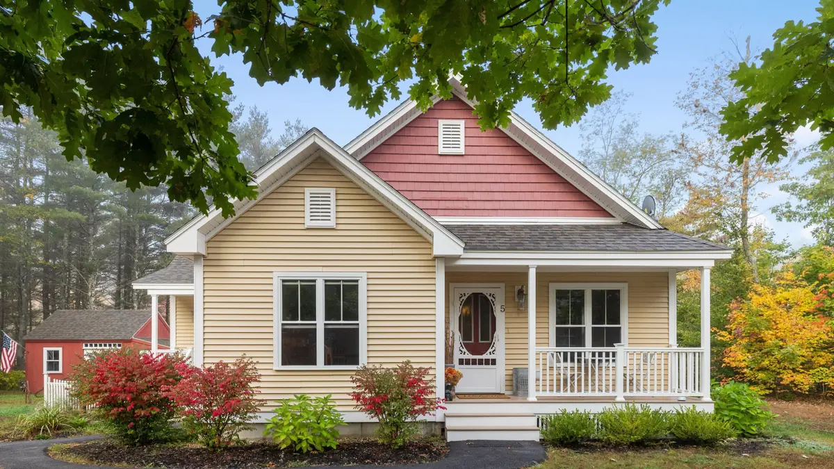 Victorian-era house with a front porch on a tree-lined hillside street in Malden, Massachusetts